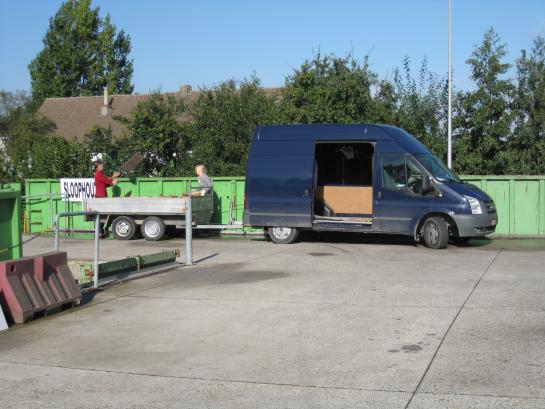 mensen laden bestelwagen uit op recyclagepark