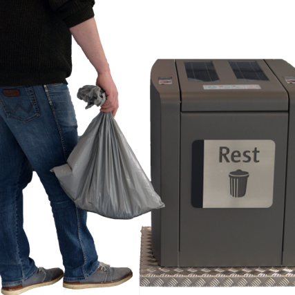 man draagt afvalzak naar ondergrondse afvalcontainer